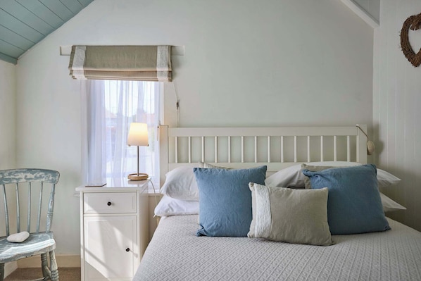 Tabla de planchar con plancha y ropa de cama