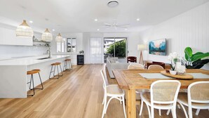 A modern kitchen with a central island, bar stools, and pendant lighting.
