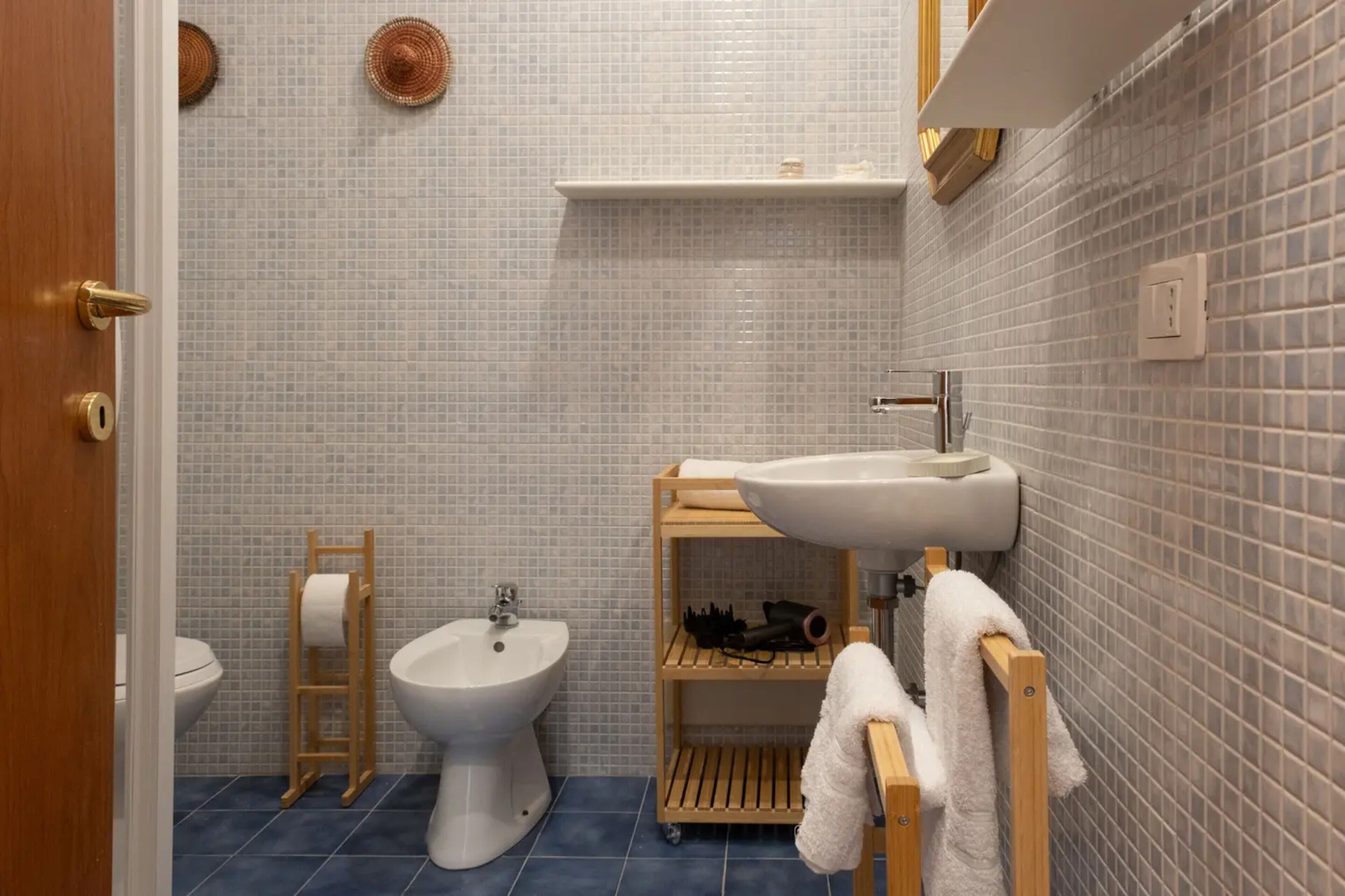 A bathroom with a toilet, bidet, and a sink with a towel rack.