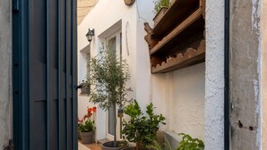 A narrow alleyway with potted plants and a door. - Holiday Home 'Barbara' with Private Garden, Wi-Fi and Air Conditioning (Teulada)