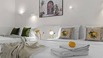 Une chambre d’hôtel avec deux lits, du linge de lit blanc, des oreillers verts à motifs, un tableau accroché au mur et des lampes de chevet.