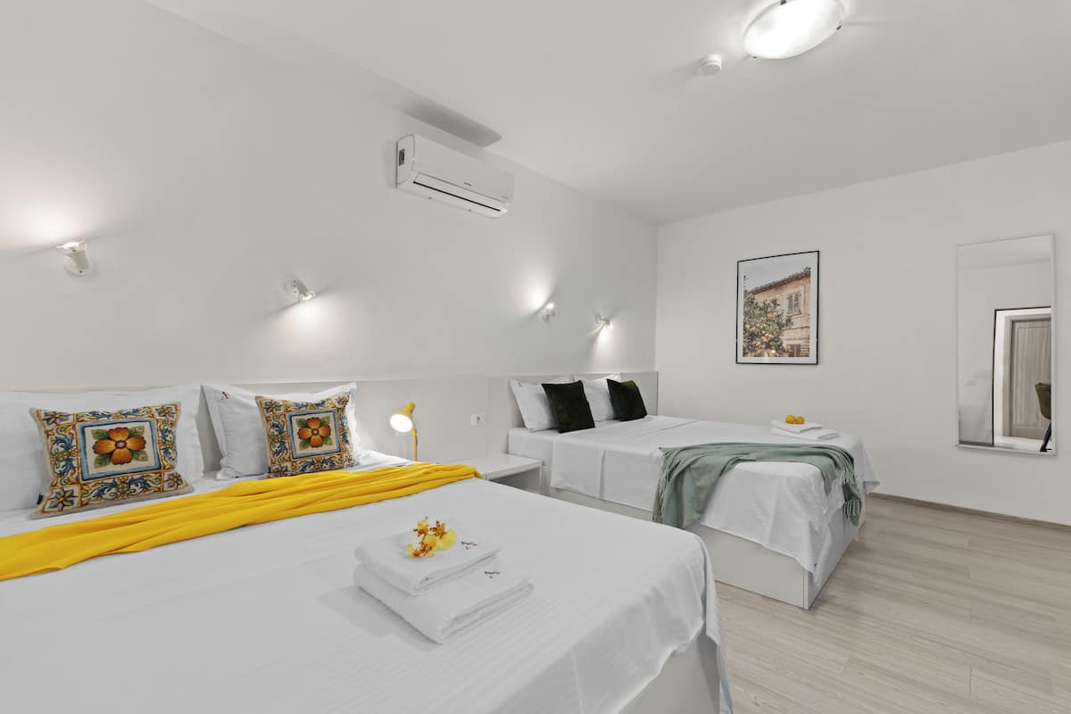 Ein Hotelzimmer mit zwei Betten, einem großen Spiegel und einem Bild an der Wand.