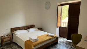 A bedroom with a bed, bedside table, and a chair. - Maripetra B&B (Sangineto)