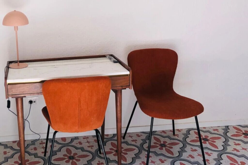 Un bureau avec une lampe et deux chaises.