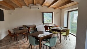 A dining area with hexagonal tile flooring, wooden tables, and chairs. - Maripetra B&B (Sangineto)