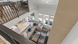 A spacious living area with a large sectional sofa, a coffee table, and a view of the outdoors through large windows. - Chaparral 204 3 Bedroom Condo (Park City)