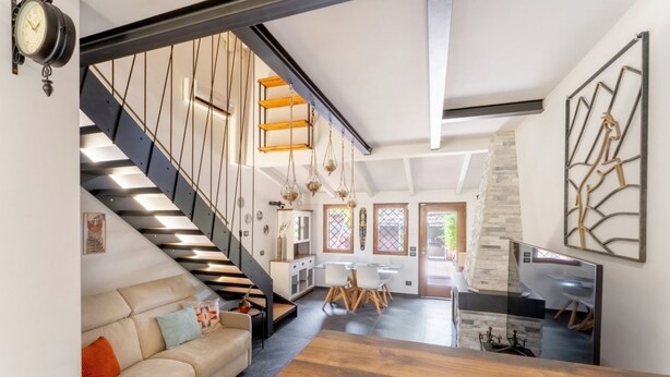 Un intérieur moderne comprenant un escalier, un coin repas et une cuisine.
