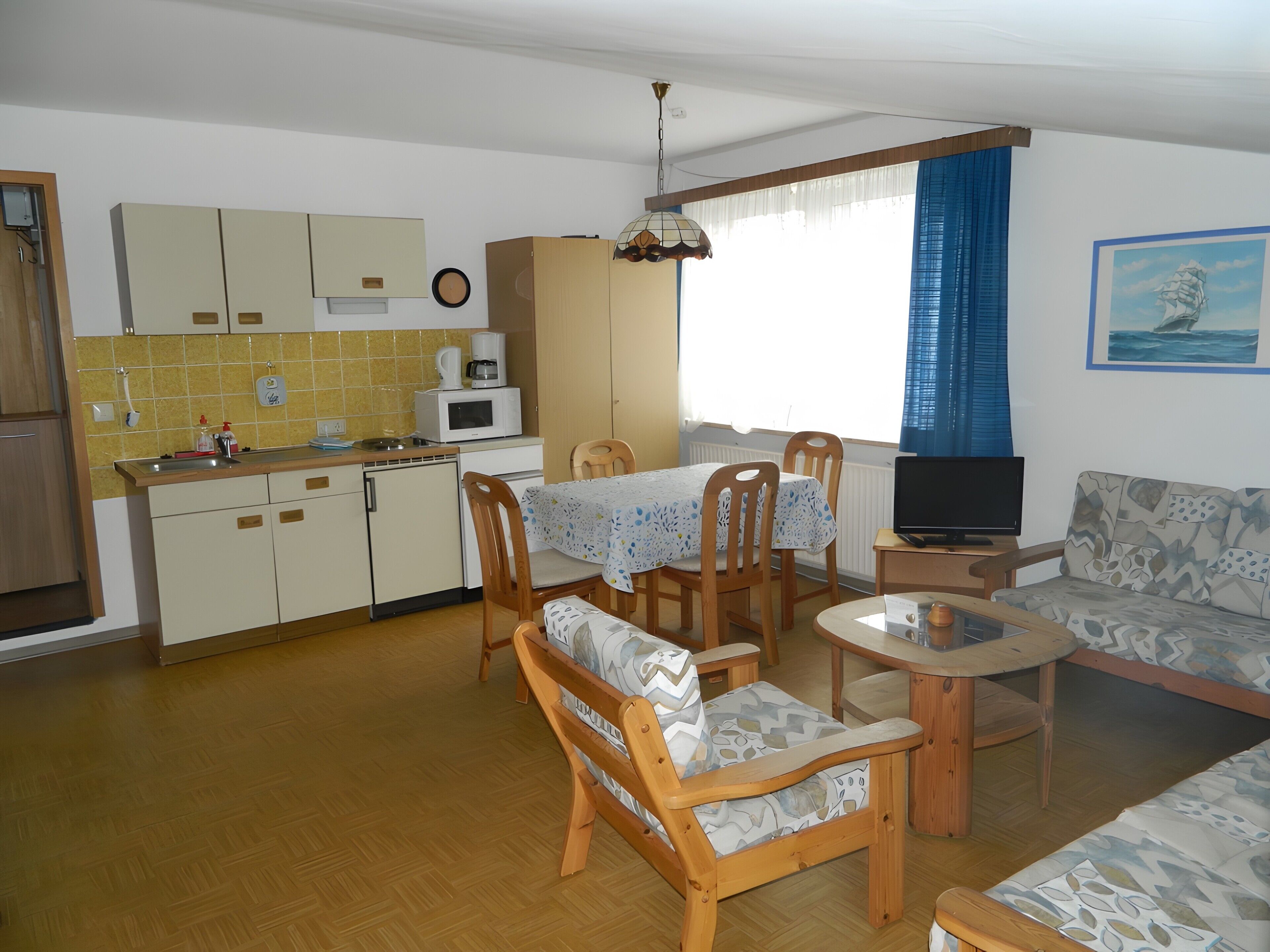 Un espacio habitable compacto con cocina, comedor y zona de estar.