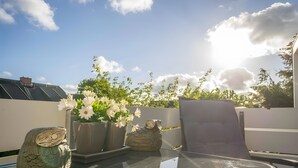 Una mesa de cristal con un búho decorativo y flores blancas.