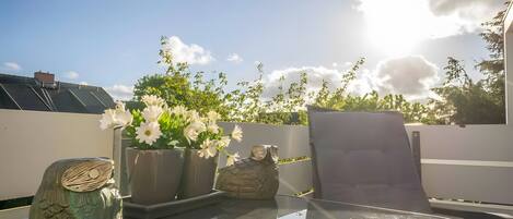 A glass table with a decorative owl and white flowers.