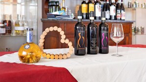 A bar area with bottles of wine and a glass on a table.