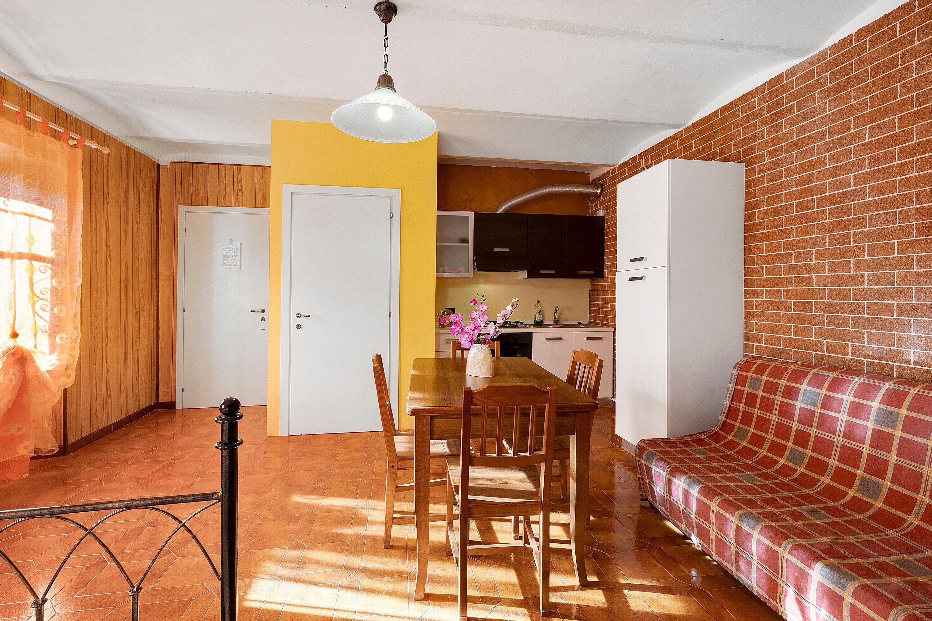 Un espace de vie compact comprenant un coin repas, une kitchenette et un canapé.