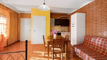 Un espace de vie compact comprenant un coin repas, une kitchenette et un canapé.