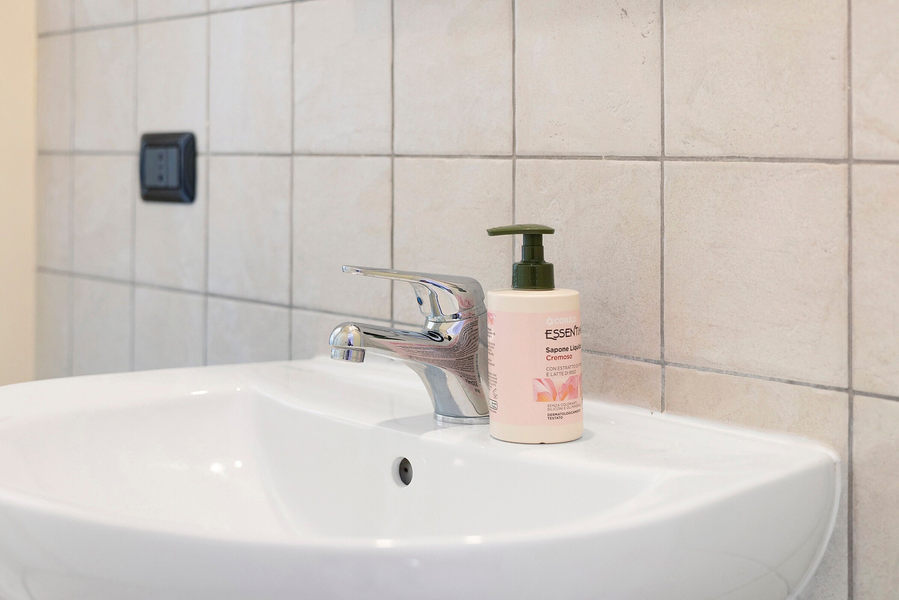 A bathroom sink with a faucet and a soap dispenser.