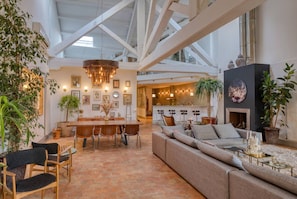 A spacious living area with a high ceiling, a dining table, and a sofa. - Grand Loft - Centre-ville - Bateau à la location (Marseille)