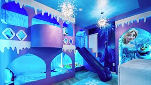A room with a bed, a slide, and a wall with a character decoration. - Family Fun Villa: Themes, Pool & Games,Resort (Clermont)