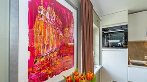 A modern kitchen with a built-in oven and a window with brown curtains. - Apartment 'Gemütliche Wohnung' with Shared Garden and Wi-Fi (Keitum)