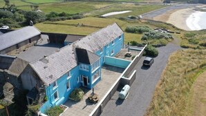 A blue building with a paved driveway and a parked car. - The Creamery at Annestown House (Tramore)