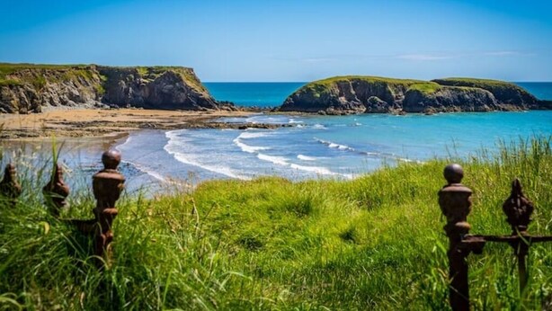 A coastal landscape with grassy areas and rocky cliffs. - The Creamery at Annestown House (Tramore)
