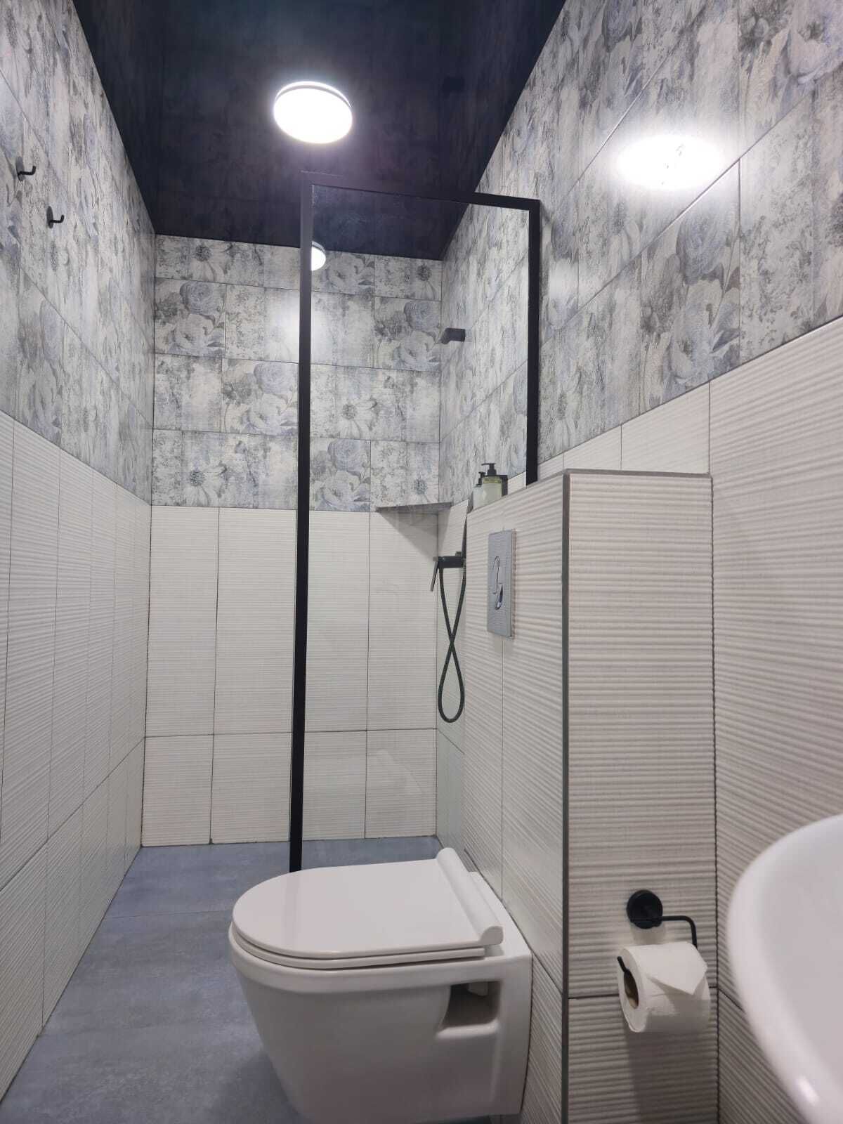 A modern bathroom with a toilet, sink, and shower.