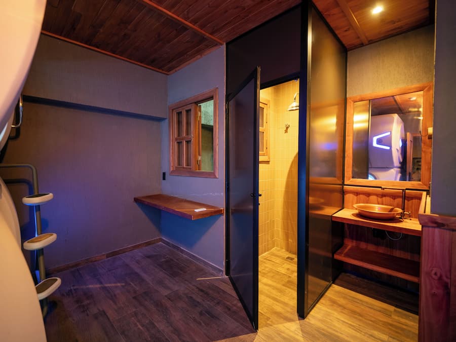 A modern bathroom with a wooden vanity, a sink, and a mirror.