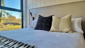 Een net opgemaakt bed met witte lakens en een deken met zebraprint.