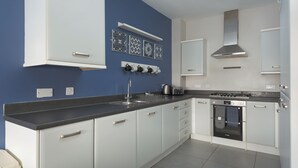 A modern kitchen with white cabinets, a black countertop, and a Bosch oven.