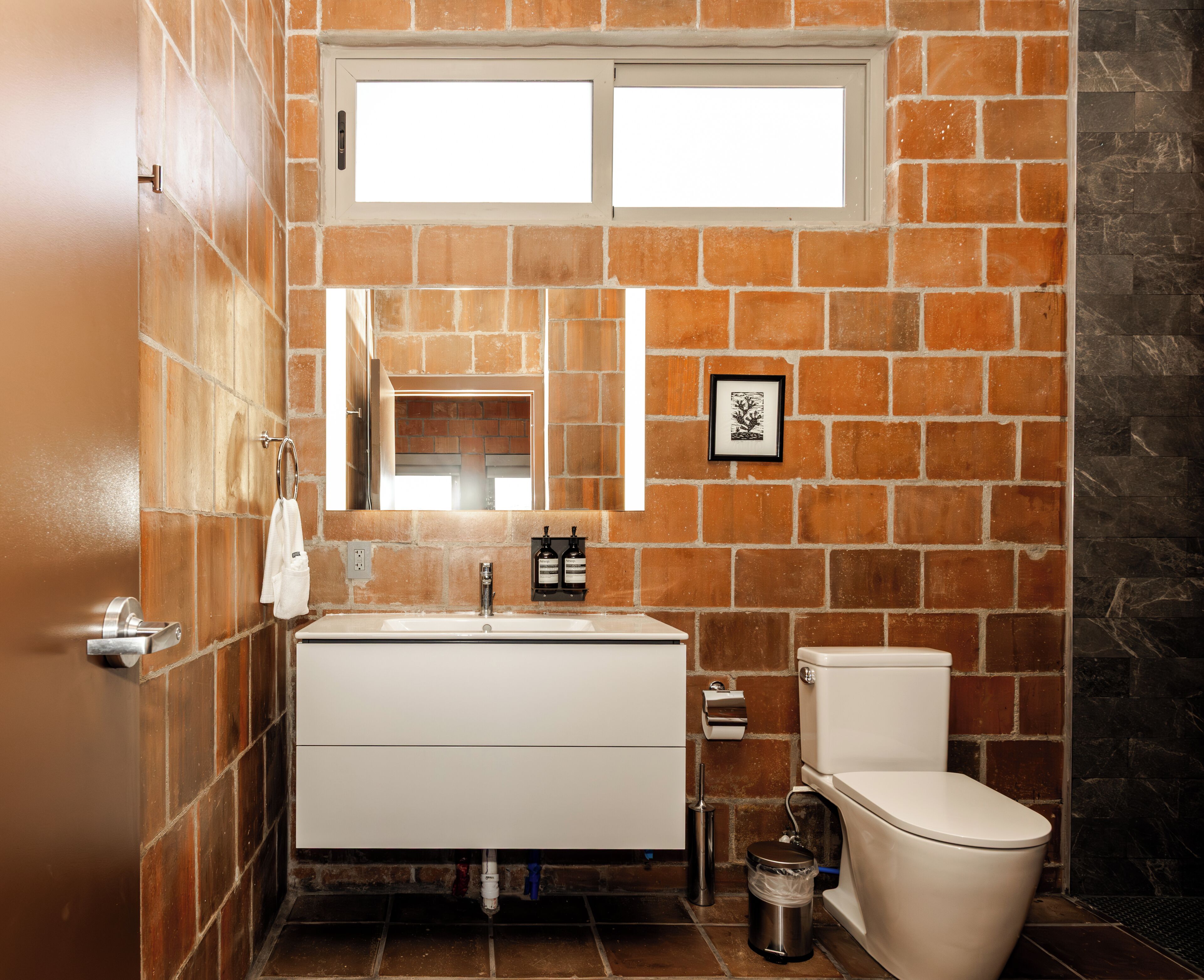 A bathroom with a white sink, a toilet, and a mirror.