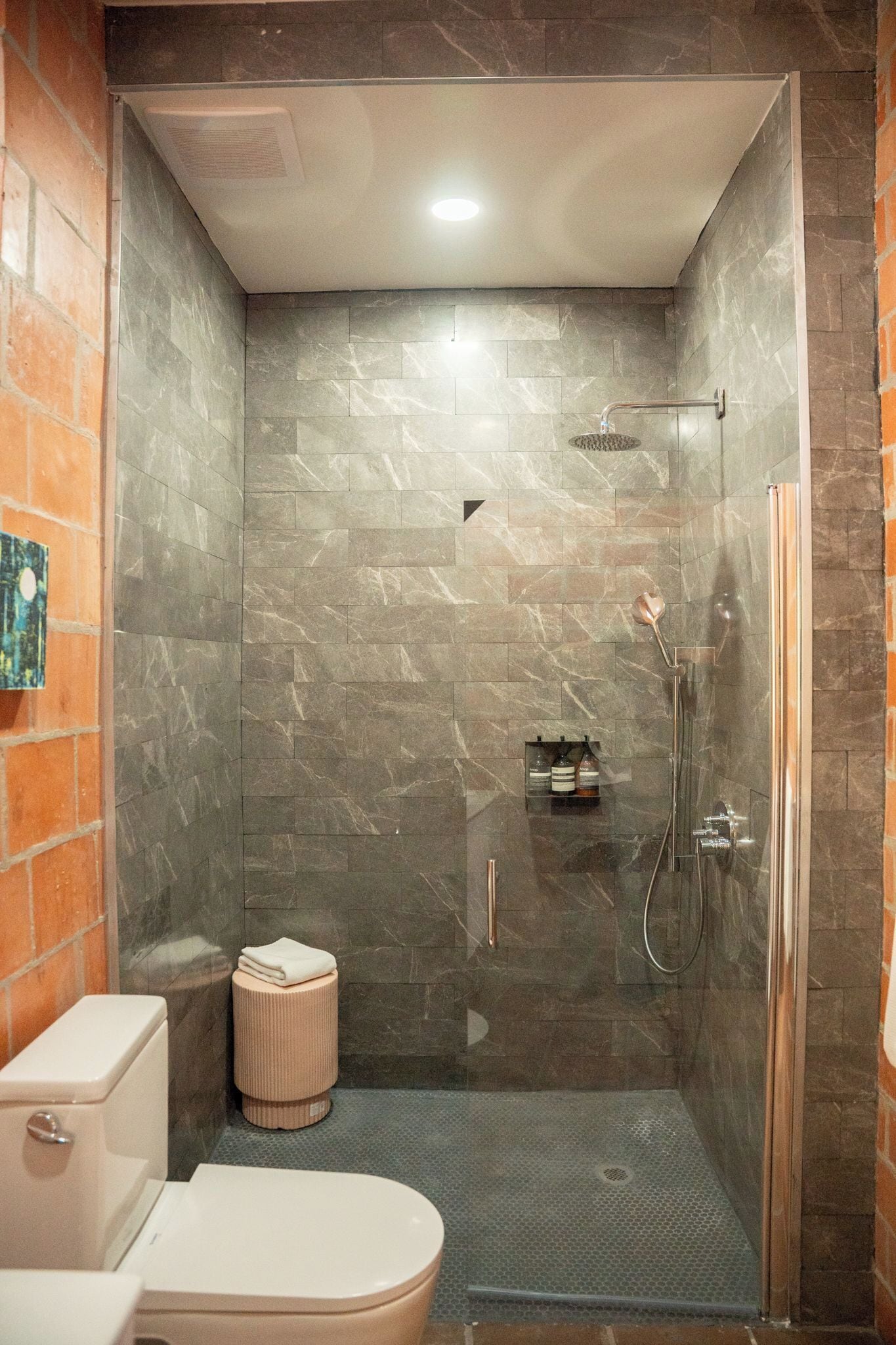 Une salle de bain avec une douche à parois de verre, des toilettes et un lavabo.