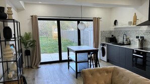 Una cocina moderna con comedor, sofá y vistas al exterior.