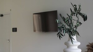 Una mesa de comedor con cuencos blancos y un florero blanco con una planta.
