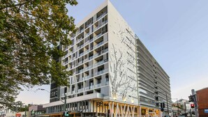 A modern multi-story hotel with a distinctive facade featuring a tree-like design.