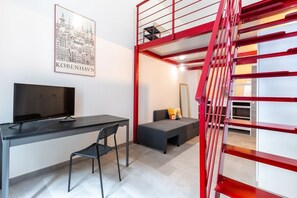 A modern room with a desk, chair, and a red staircase. - Red Loft Torino, A mix of history and trend (Torino)