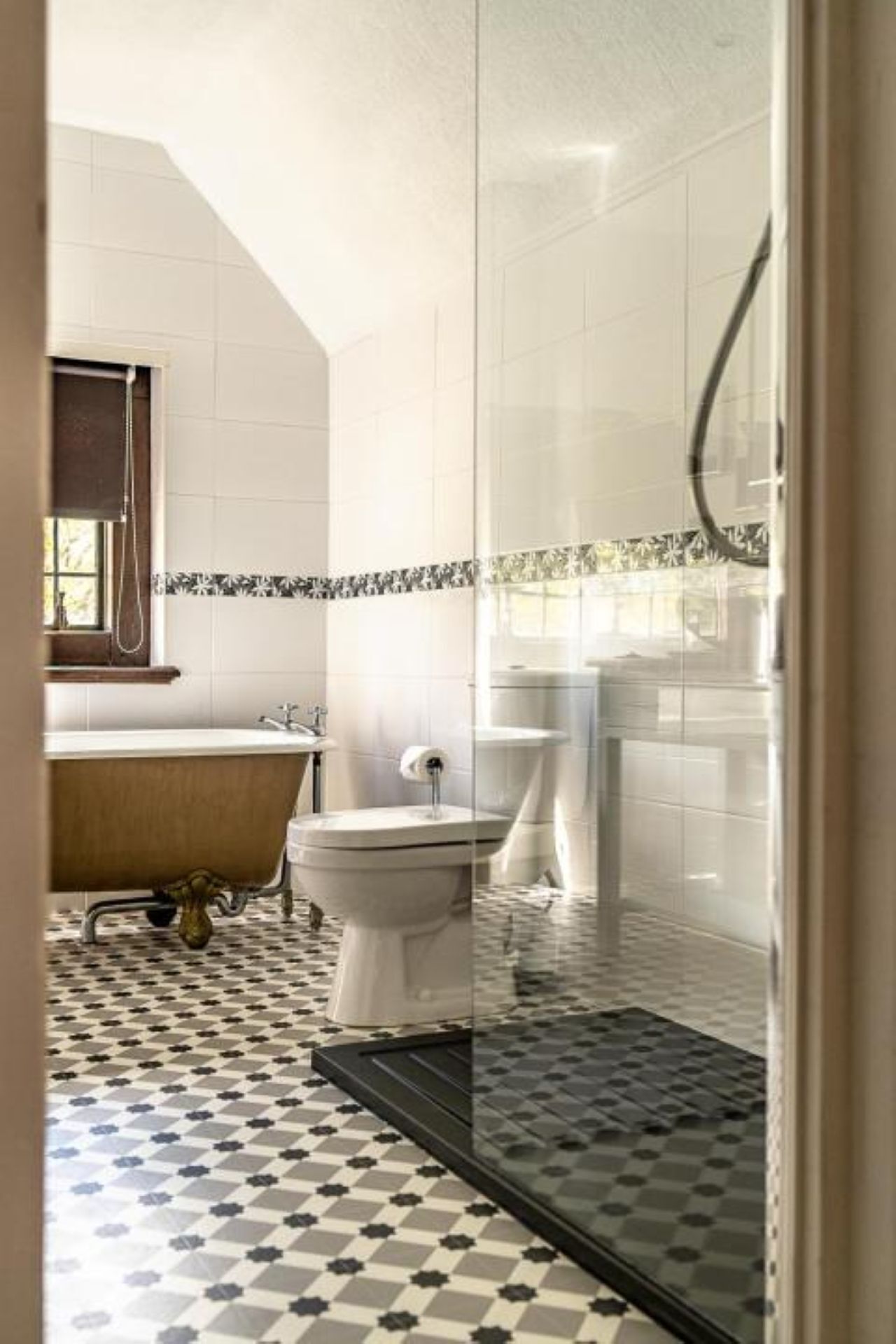 Un baño con bañera, inodoro y zona de ducha.