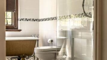 Un baño con bañera, inodoro y zona de ducha.