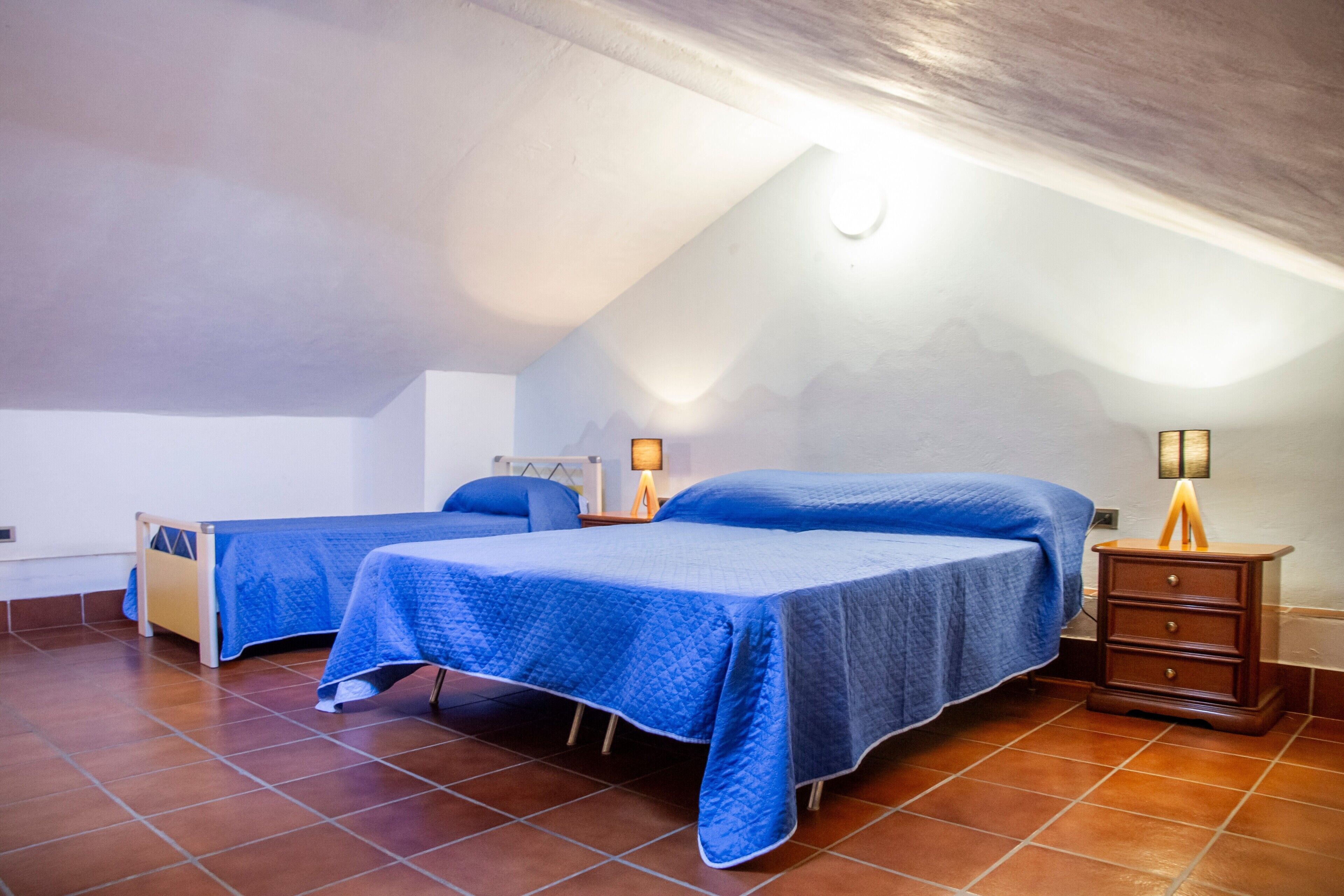 Ein Schlafzimmer mit zwei Betten, einem Nachttisch und einer Lampe.