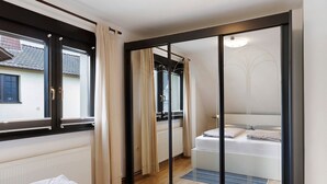 A bedroom with a bed, a sliding glass door, a radiator, and a window with curtains. - Apartment 'Gundlach' with Shared Terrace, Shared Garden and Wi-Fi (Hessisch Lichtenau)