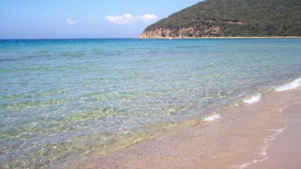 A beach with clear water, a sandy shore, and a hill in the background. - Apartment 'Taverna' with Private Terrace, Shared Garden and Wi-Fi (Gavorrano)