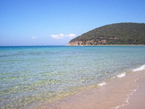 A beach with clear water, a sandy shore, and a hill in the background. - Apartment 'Taverna' with Private Terrace, Shared Garden and Wi-Fi (Gavorrano)