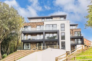 A multi-story modern building with large windows and a flat roof.