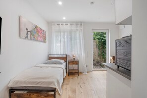 Une chambre à coucher avec un lit, une table de chevet et un tableau accroché au mur.