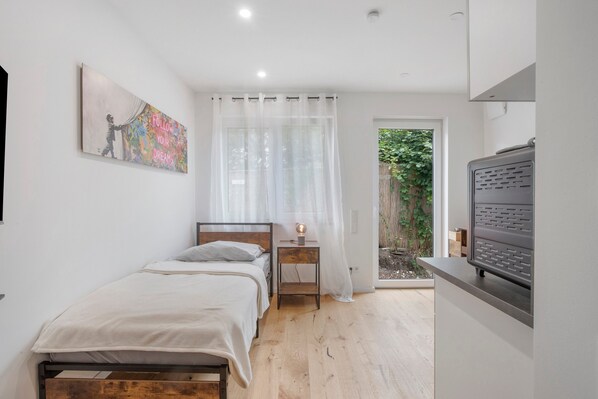Un dormitorio con cama, mesita de noche y un cuadro en la pared.