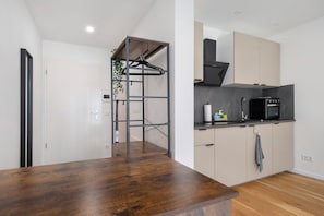 A modern kitchen with a wooden countertop, a hanging rack, and a built-in oven.