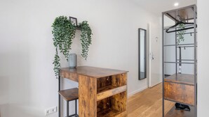 Une pièce avec un bureau en bois, un miroir et une plante.