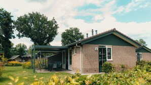 Ein Backsteinhaus mit überdachter Terrasse und einem Schild mit der Nummer 13.