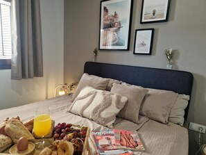 A neatly made bed with a magazine, a glass of orange juice, and a fruit tray. - Casa de Femmie - Two Bedroom Apartment, Sleeps 4 (Pulpí)
