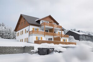 Ein mehrstöckiges Gebäude mit einem Balkon, umgeben von Schnee.