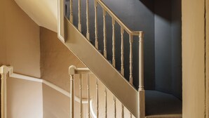 A staircase with wooden balusters and a white handrail. - Hermes Hotel by Nestor (Kingston Upon Thames)