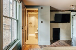 Ein modernes Interieur mit Holzboden, Kamin und Wandfernseher.