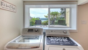 A laundry room with a view of the outdoors, a window, and a sign that reads "LAUNDRY ROOM WASH DRY FOLD REPEAT". - Oceanfront boho cottage in Bremerton (Bremerton)